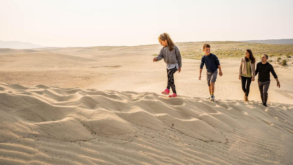 family climbing a sand dune in Rock Springs and Sweetwater County