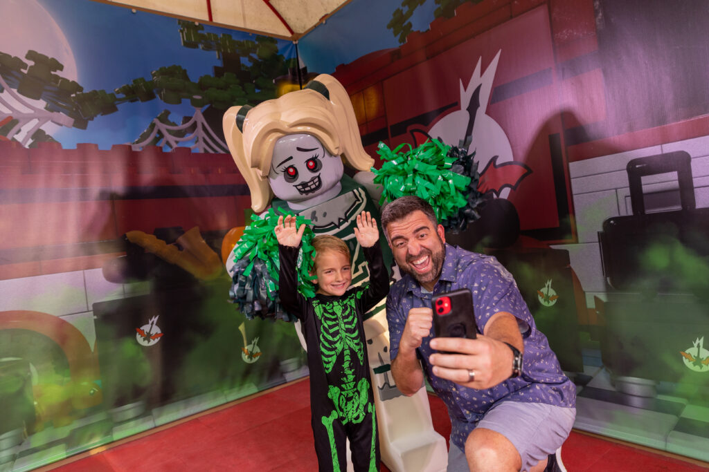 dad and child posing with vampyre cheerleader at brick-or-treat presents monster party