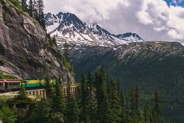 Skagway Alaska train with snow-capped mountains in background