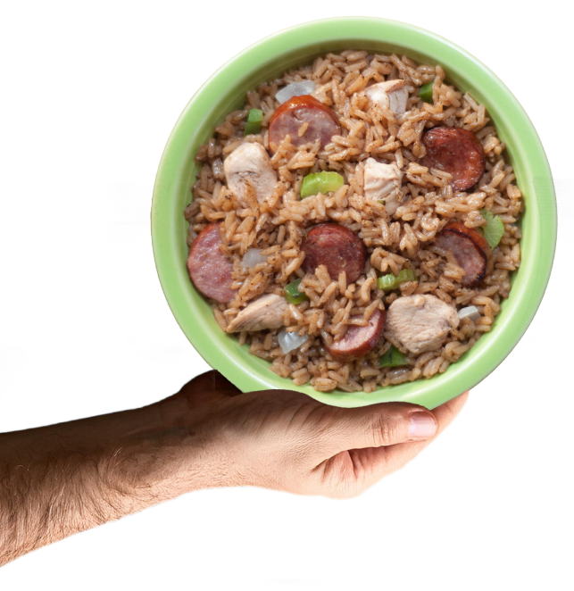 A hand holding a bowl of Chicken and Sausage Jambalaya